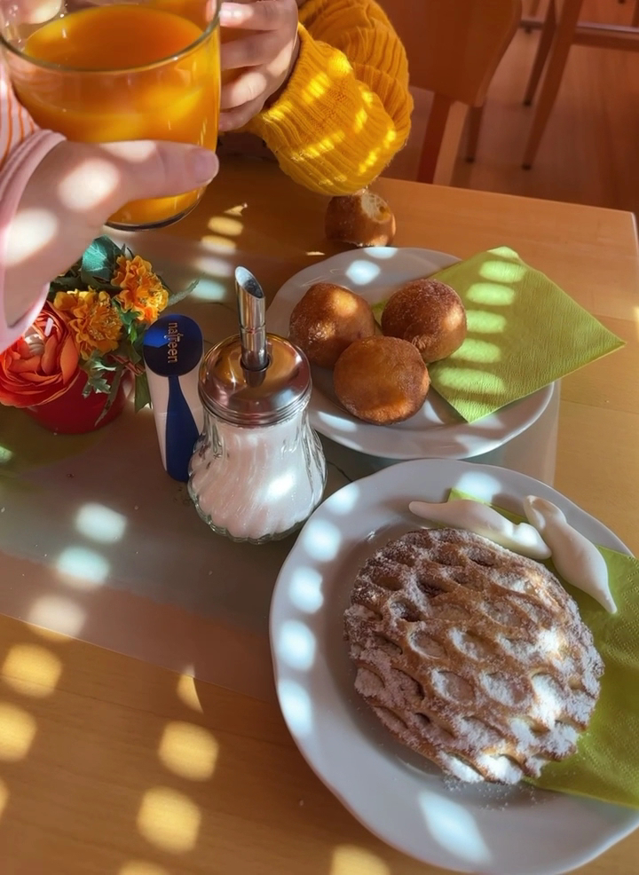 Frühstückstisch im Stehcafé mit Krapfen und Orangensaft