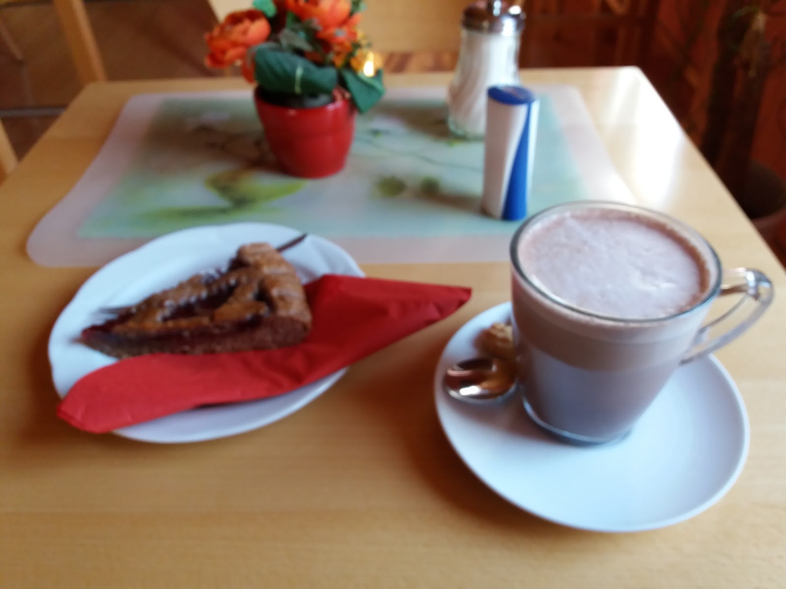 Stück Linzertorte mit einer heißen Schokolade